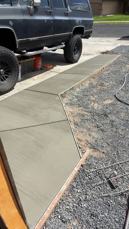 Finished concrete walkway running alongside a home's driveway