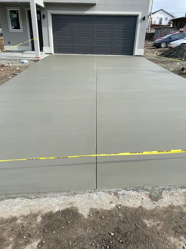 New concrete driveway leading to a modern two-car garage