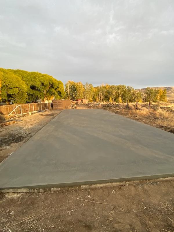 Long straight concrete driveway extending into the distance under a cloudy sky