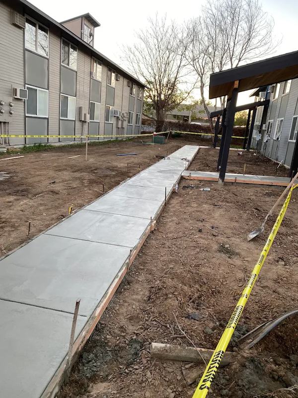 Newly poured concrete walkway between apartment buildings