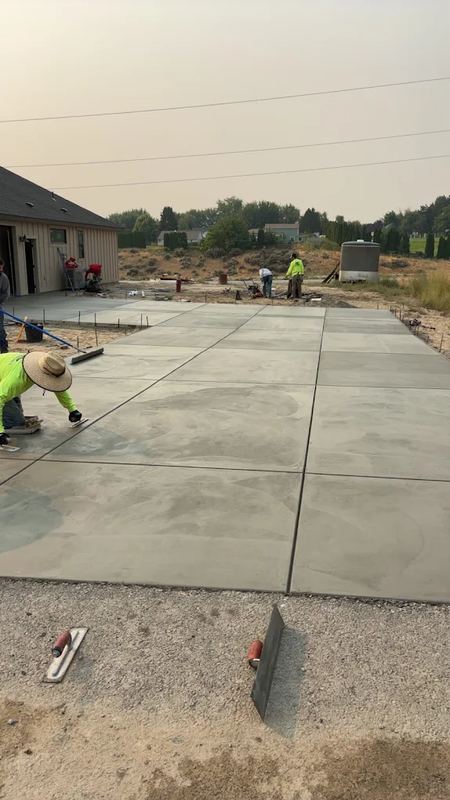 Concrete crew hand-finishing the edge of a large fresh slab