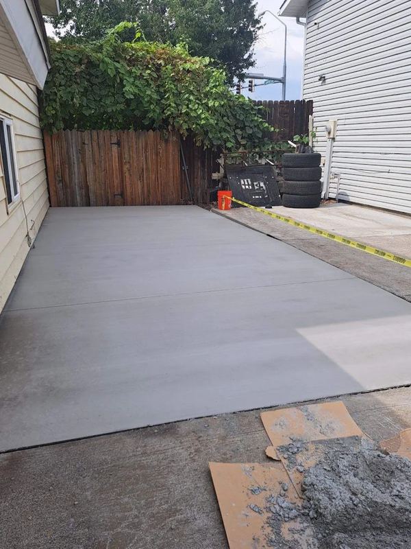 Finished concrete pad along the side yard of a home