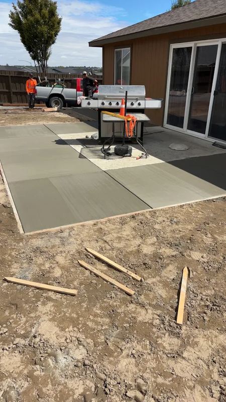 Concrete patio poured next to an outdoor kitchen and grill